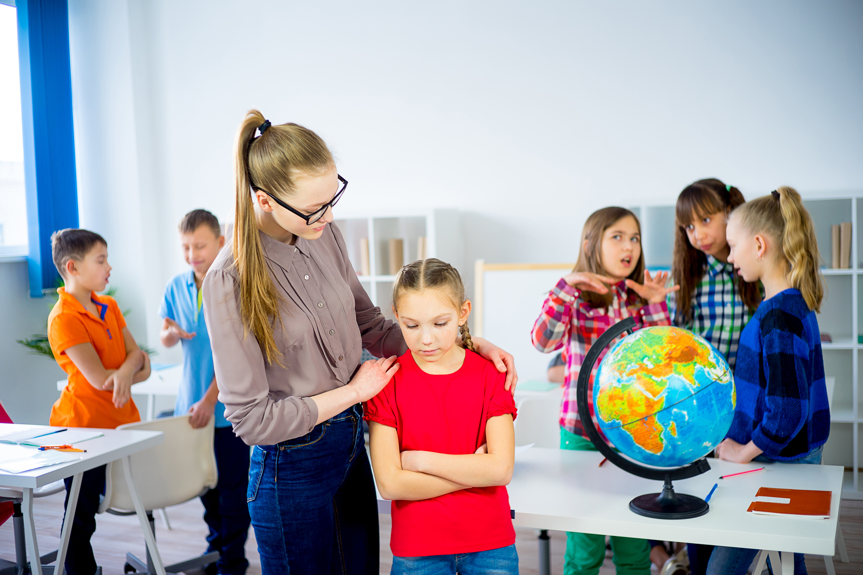 Teacher calms stressed pupil in the classroom as a part of teacher wellbeing